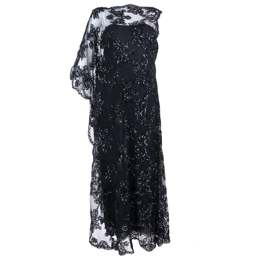 Elegant black chiffon sheath overlaid with black lace caftan embellished with sequins. Fully lined with boned bodice.