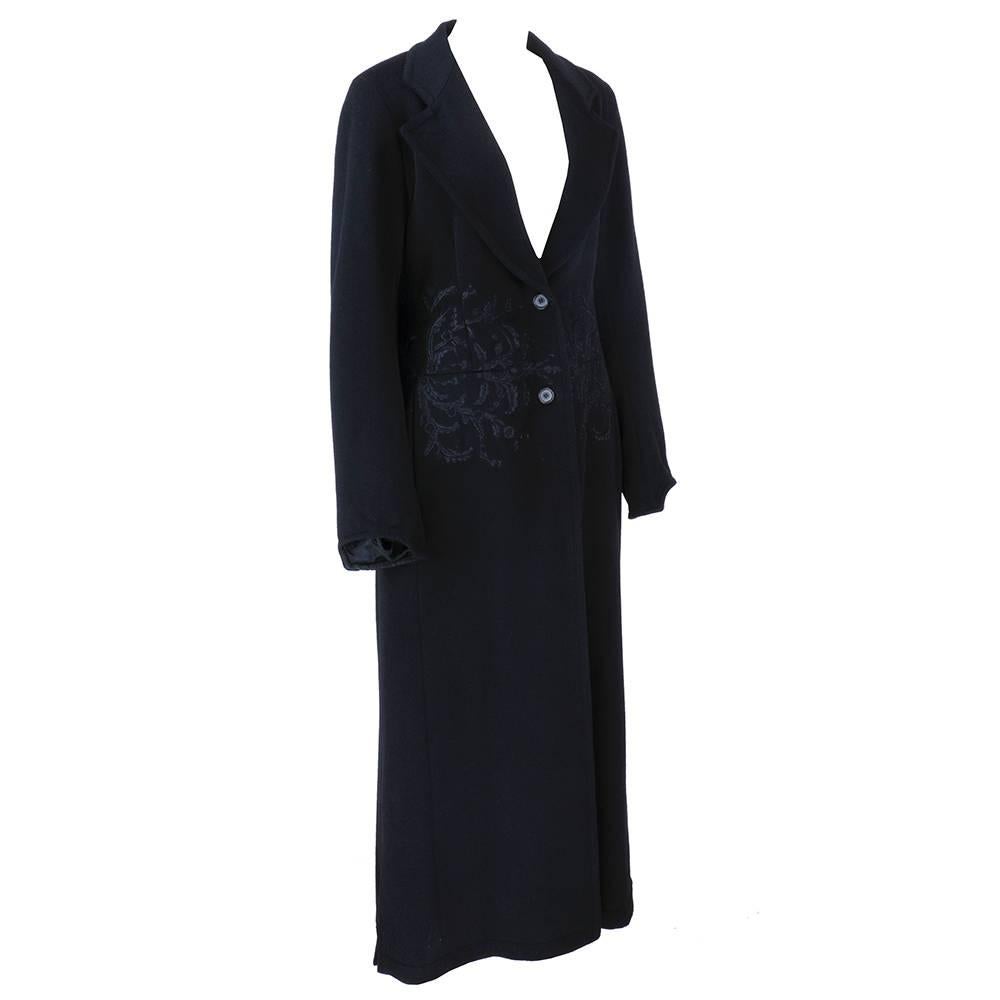 Gorgeous black wool coat by Dries Van Noten . Embroidered around waist, slash pockets and adjustable sash that can be worn front or back. Interesting cuff detail. Full Length.  Never worn.