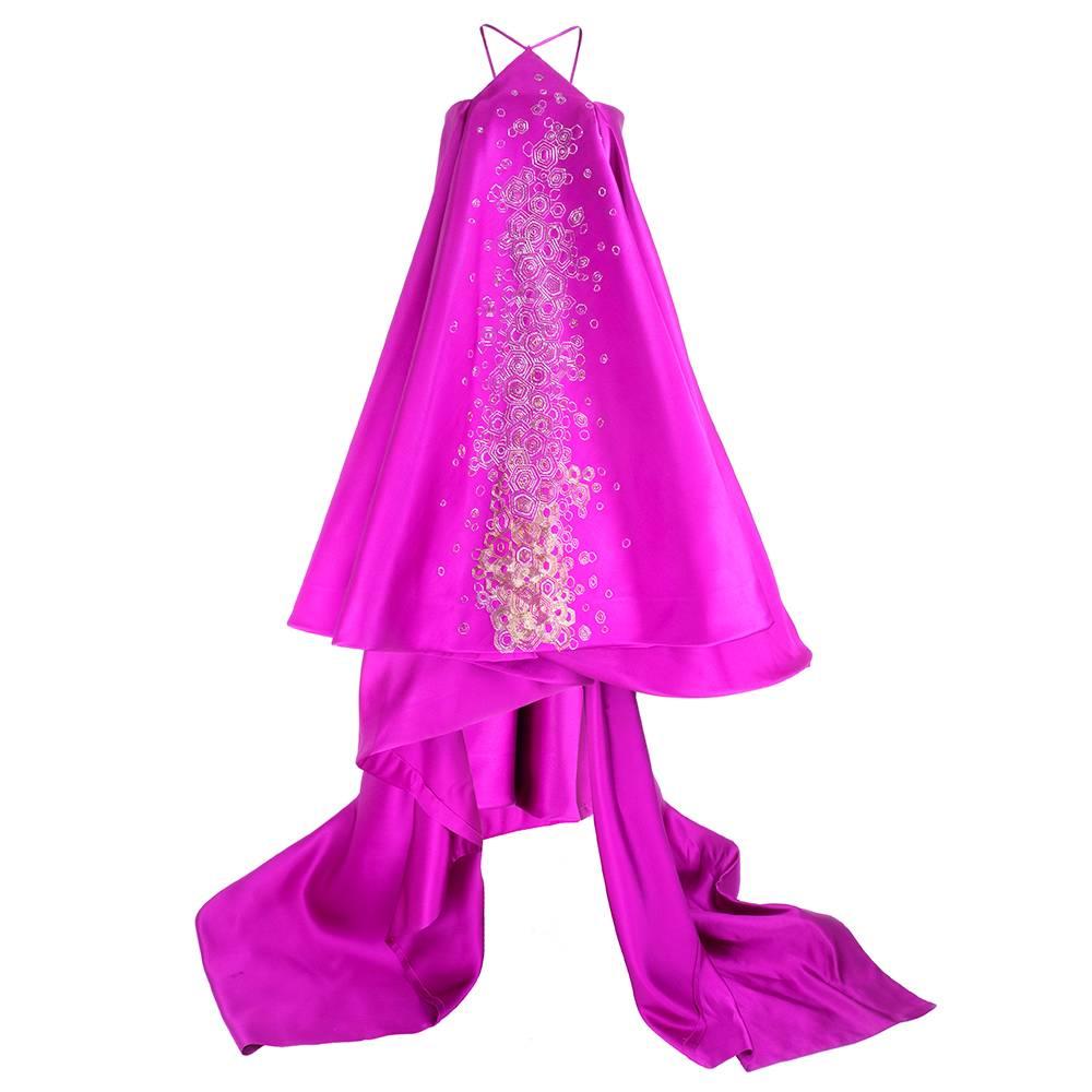 Gorgeous ball gown of magenta silk satin - short in front long in back with sweeping train.  Beading and embroidery work down center front with beautifully cut triangle halter neck. Boned bodice  and fully lined. Meant for the red carpet!

Center