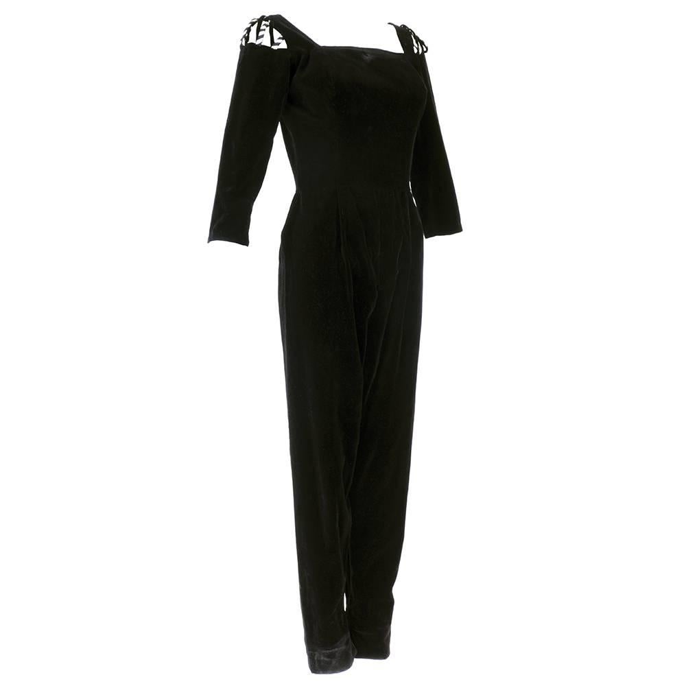 From Great american designer Tina Leser. Playful hostess wear in the form of a black velvet catsuit with peekaboo striped strap detail at shoulder. Zips up the back.