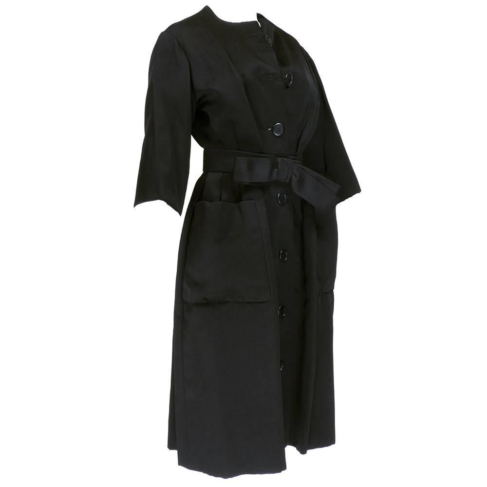 Stunning Yves Saint Laurent era Christian Dior haute couture dress from the spring/summer of 1959. Black silk faille coat dress with belt. Gathered skirt with oversized patch pockets. Top 2 buttons decorative. Excellent condition. Once in a lifetime