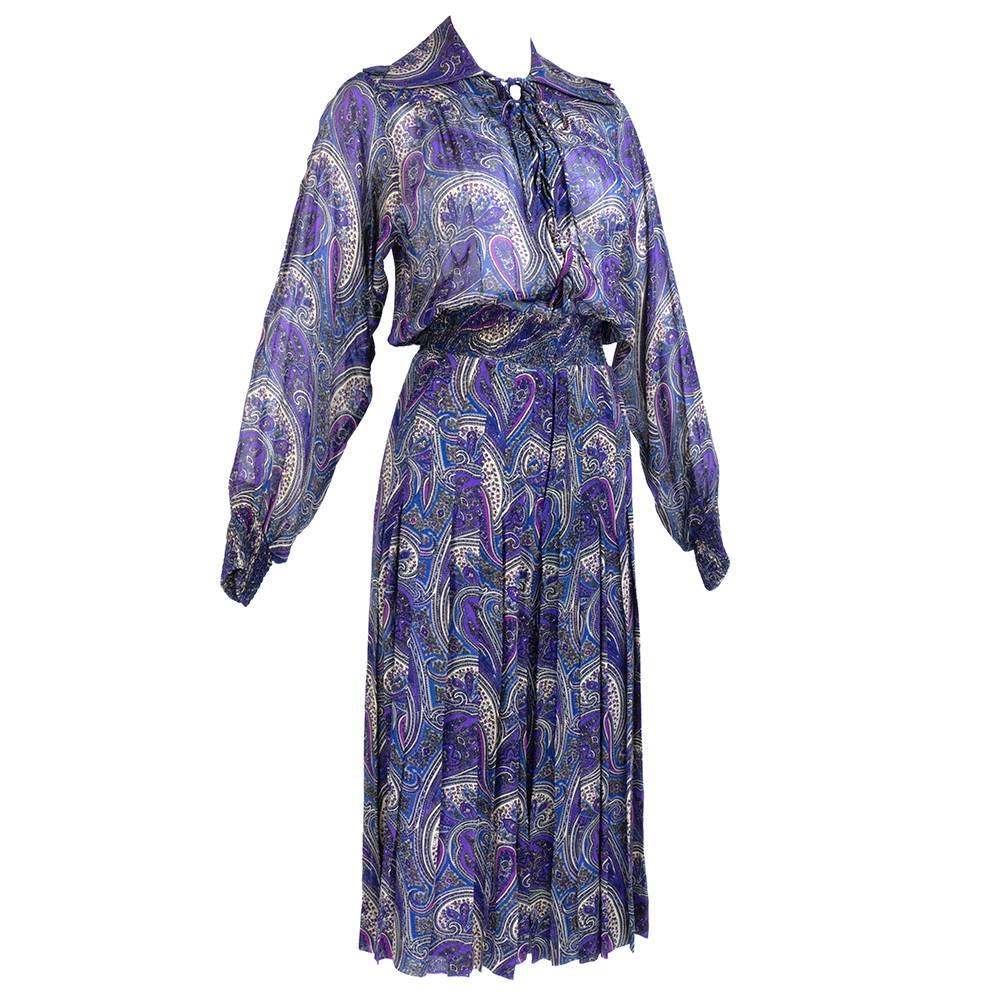 Super chic purple, paisley print one piece. Laces up neck, smocked waist and cuffs and pleated full split skirt. Sheer poly blend that zips up front. 
