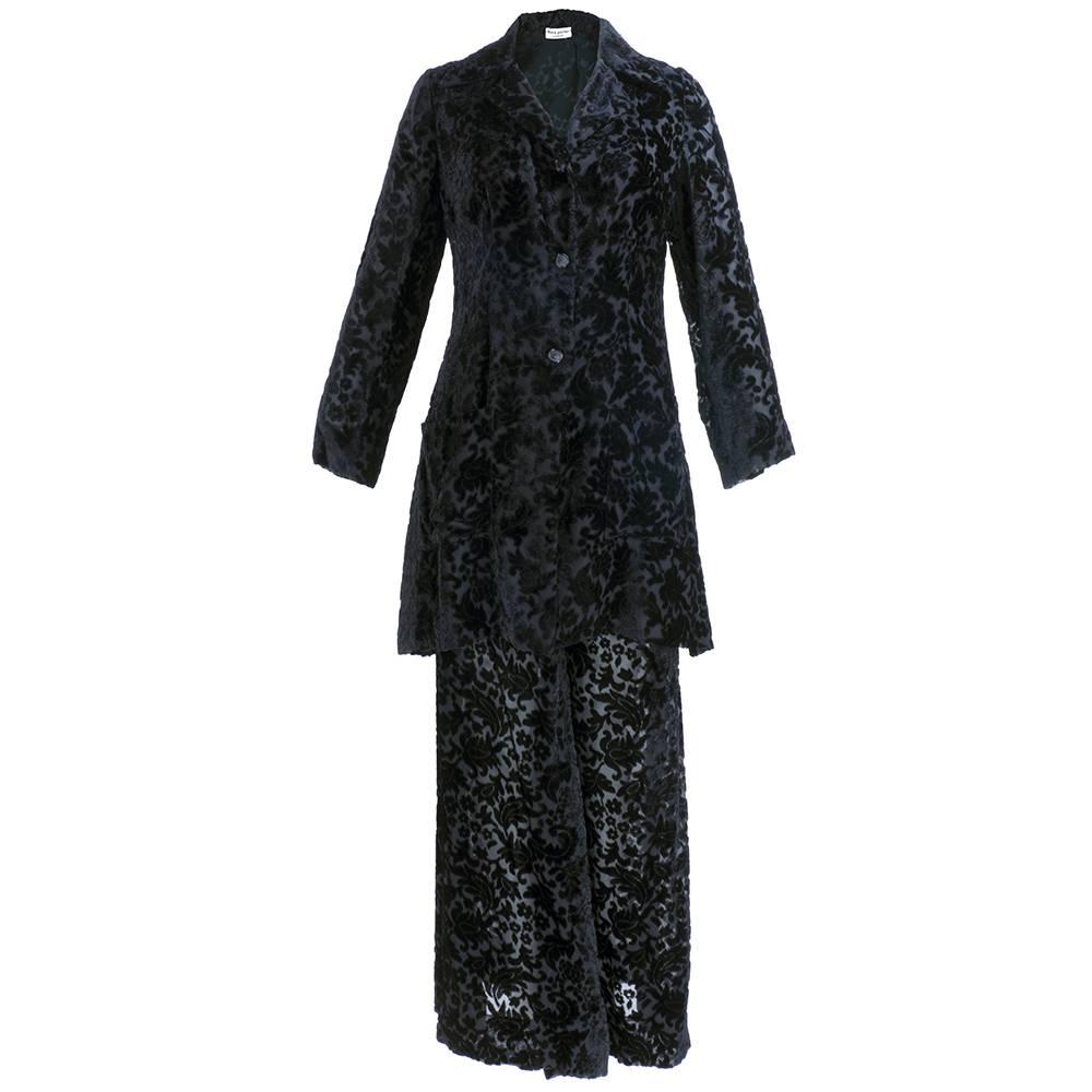 Rare and beautiful two piece ensemble by iconic designer Thea Porter. Sheer black cut velvet in a stylized floral motif. Long tunic jacket buttons down the front paired with super-wide bellbottom pants in matching fabric. Backed with chiffon. 