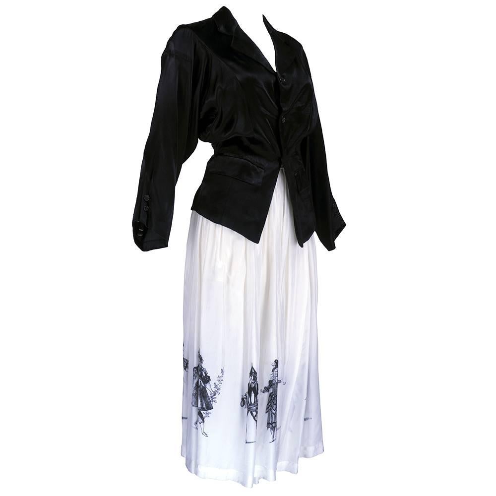 Wonderful, whimsical ensemble by Comme des Garcon circa 1988. Black silk/rayon blend fitted jacket with interesting tailoring with full white harem style pant/skirt with Commedia dell'arte print. Skirt measures 32" in length.