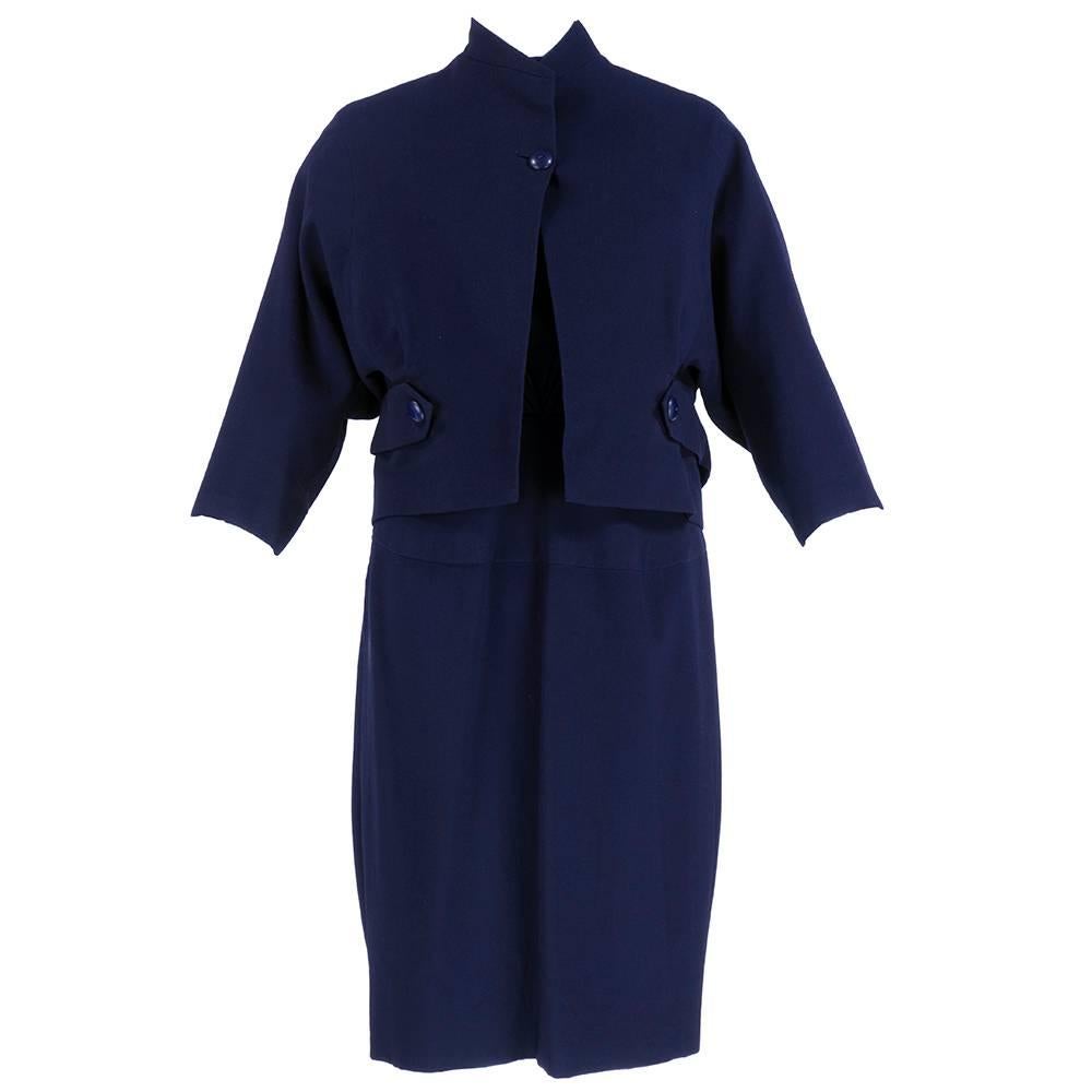 Chic blue wool dress with jacket. Wonderfully tailored by italian fashion house Fabiani. Ingenious radiating pleats on bodice with 3/4 sleeves and side zip. With sack cut Raglan sleeve cropped jacket with detachable side belts.  Jacket is fully