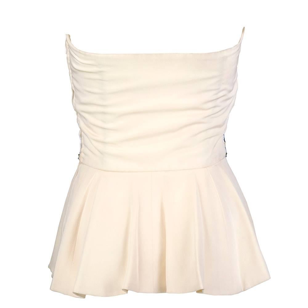 Elegant ivory strapless top by Lanvin circa 1990s. Fully lined and banded by a diamond pattern of sequins with floral motif. Peplum hem. Great statement piece.