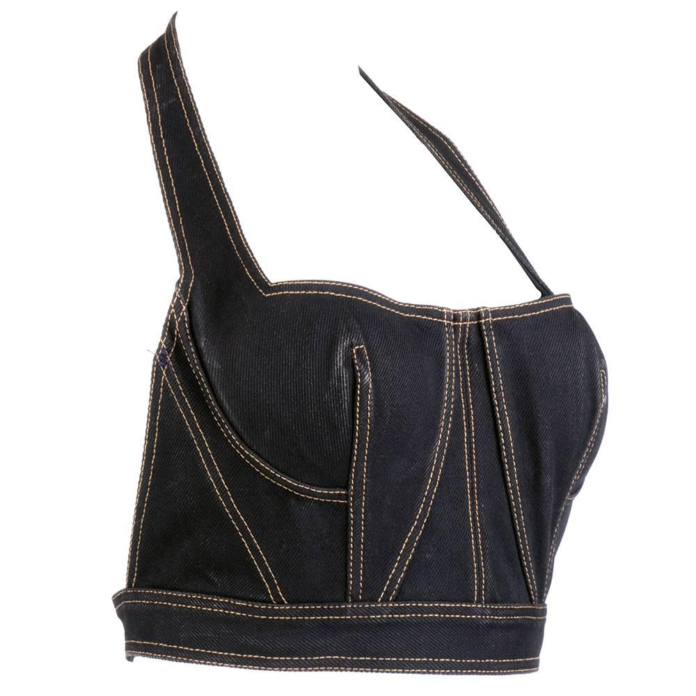Classic Azzedine Alaia sexiness in this black denim halter style bustier. Strategic topstitching emphasizes the female form.  Fully boned, slips over head and buckles around torso. Slight color loss at center bust - looks like natural patina. 