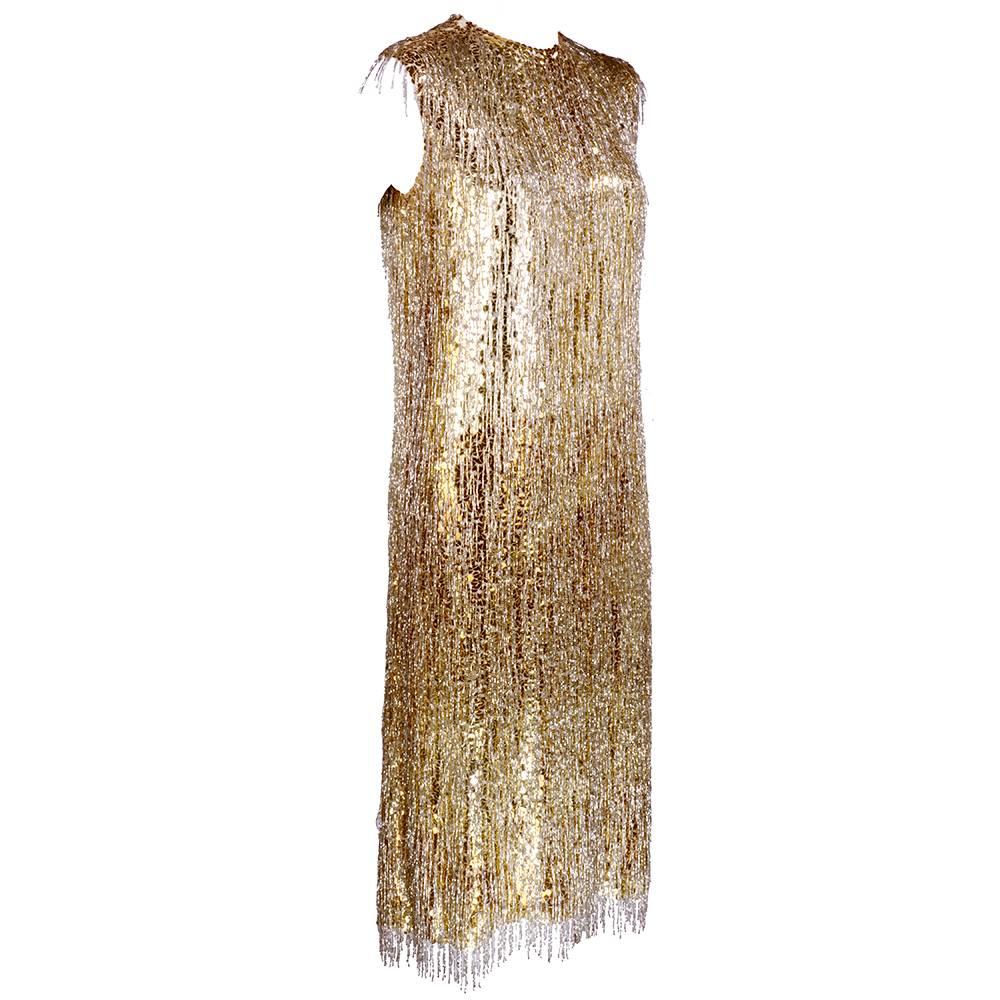 Stunning sheath of gold sequins and silver beaded fringe attributed to great American design Norman Norell. Mid length, silk chiffon lined and zips up the back.  Fabulous subtle ombré with the sequins.  Moves beautifully when worn. 