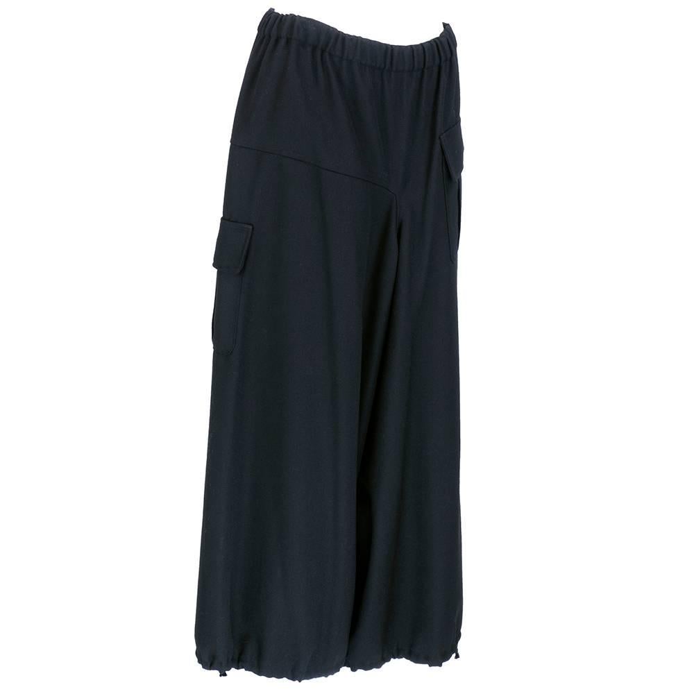 100% medium weight wool twill wide leg cargo style pants. Elastic waist, asymmetrical patch pockets and drawstring cuffs. Sizing flexible due to elastic waist - would fit 30 inch to 34 inch waist.  