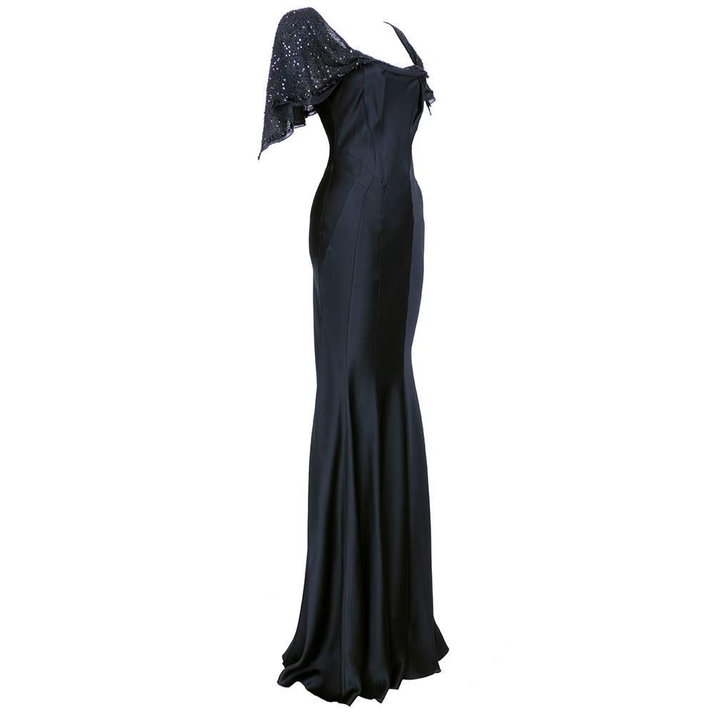Super sexy 1930 style bias cut satin gown by John Galliano circa early 2000s. New with tags. Beautifully seamed with attached capelet of chiffon coveredin sequins, beads and trimmed with bows. Zips down back. Tag size 40.

Bust: 32 inches
Waist: 26