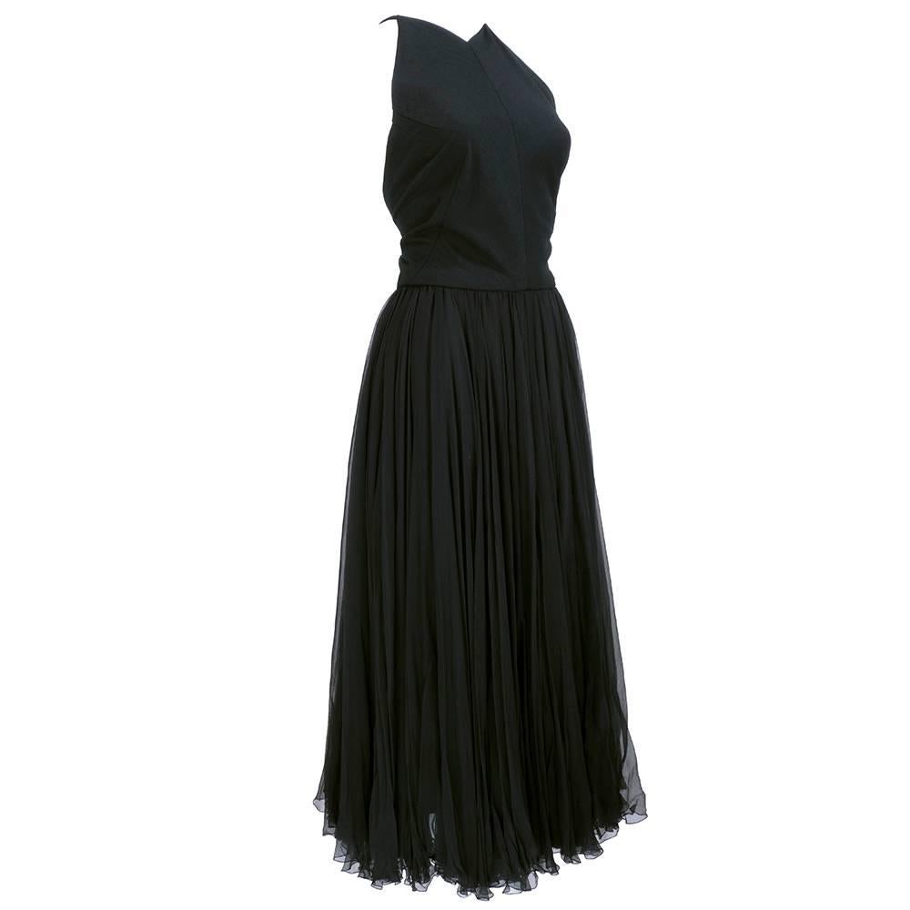 Sweet and sexy little black dress circa 1950s. wool jersey blend halter top with criss cross back and full multi-layered chiffon skirt. Zips up back with hook and eye clasps at straps.

Waist to hem:  32 inches