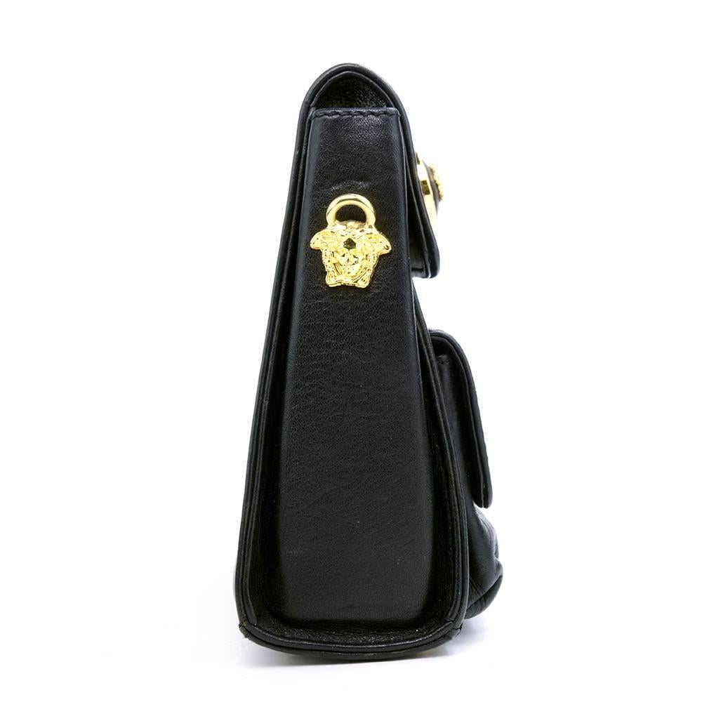 Elegant and dramatic small cross body bag by house of Versace. Lifetime Gianni Versace piece. Black leather pouch with two outer pockets and one inner. Bright gold tone chain with medusa head hardware. Rare and wonderful piece.

Strap: 45 inches