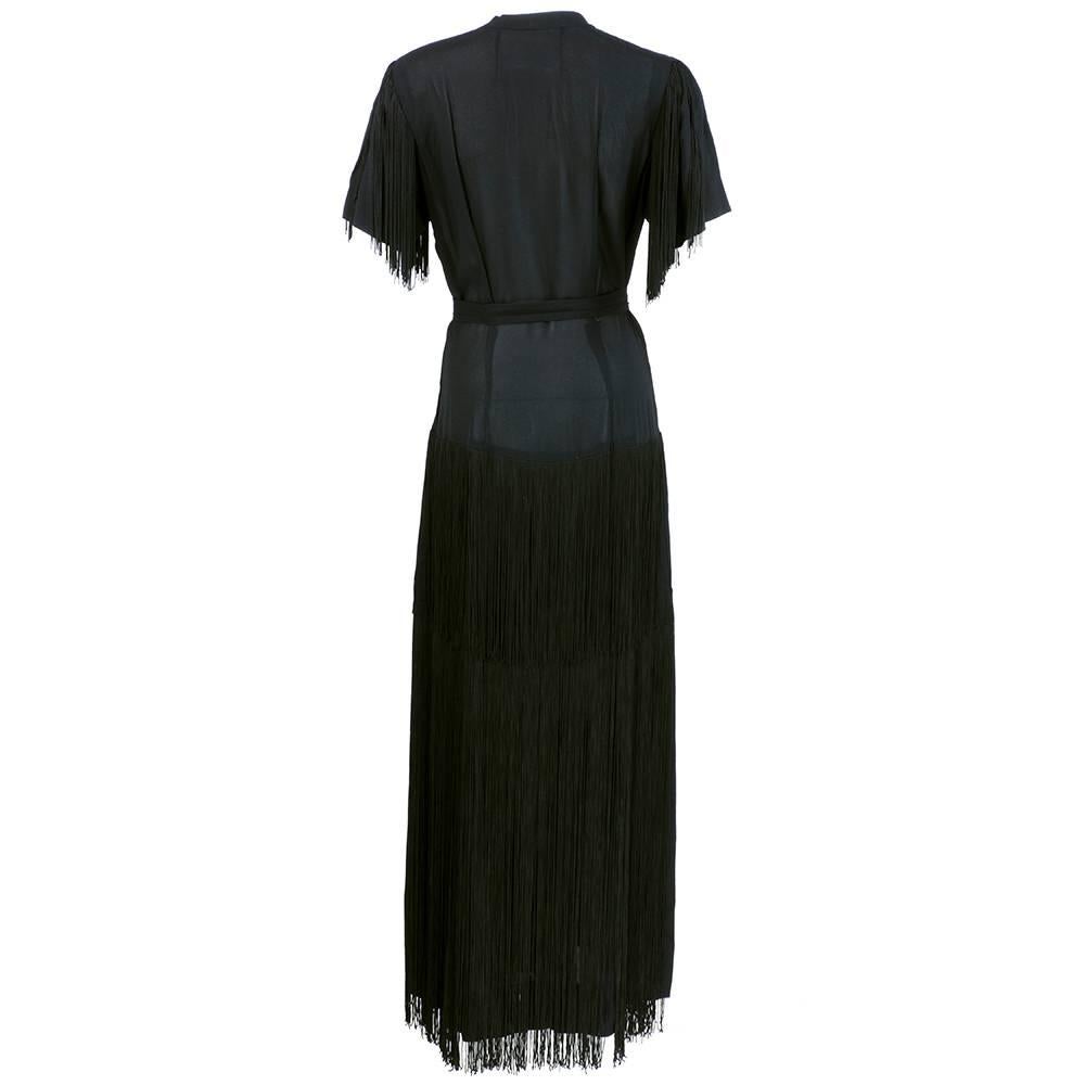 Dramatic and gorgeous gown circa 1940s in black crepe. Fully fringed in layers from waist to the floor. Interesting pleating at neckline - which plunges in a deep V. Detached sash with straight skirt. Lightweight and slightly sheer.