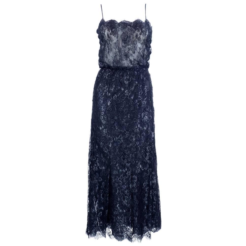 1970s era Christian Dior black lace evening gown with a coordinating lace jacket embellished with oblong strips of mylar.  Sheath style which snaps and zips up side, Lightweight, sheer and lined in chiffon. Great disco era elegance. Scalloped edges.
