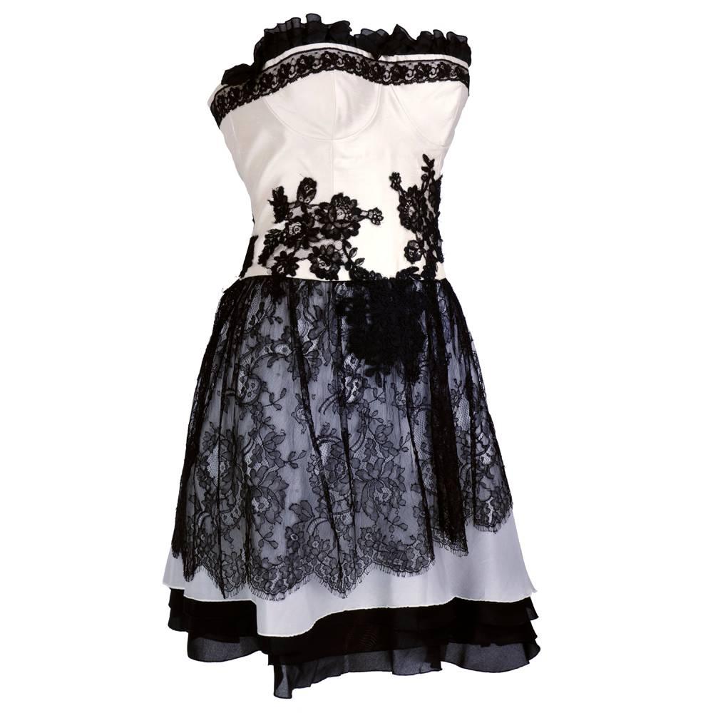 Quintessential Christian Lacroix look from the 1990s. Ivory and white slug silk bodice with lace appliqué and black silk organdy triple ruffle edging. Skirt is made of 4 layers of graduating organdy with a black chantilly lace overlaid on top.