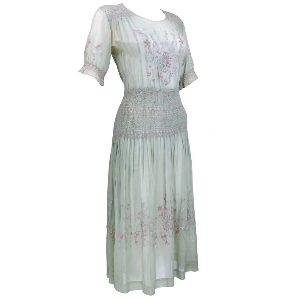 Classic 1920s short-sleeved drop-waisted dress in pale sage green with pale pink, green and lavender embroidery.  Hip smocking covers nearly 8 inches and the surface design consists of everything from drawn work, faggoting, french knots and satin