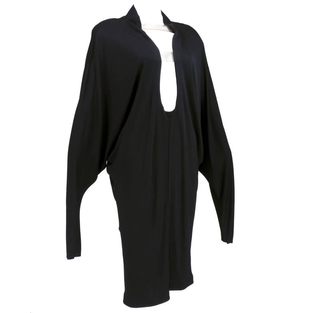 Uncharacteristic piece by designer Thierry Mugler - black matte rayon jersey oversized inverted tunic style with deep cut neckline cut with several clear plastic panels. Extreme bat-wing sleeves with a hip-hugging skirt.  Ultra-modern style from the