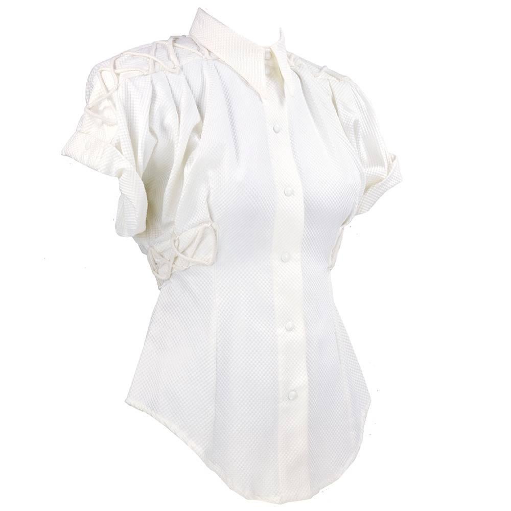 Blade Runner moment Thierry Mugler blouse in white pique. Fitted with corset style lacing and snap closures. Padded shoulders, peplum style flared shirt tails and extra long peaked collar. Dramatic silhouette.
