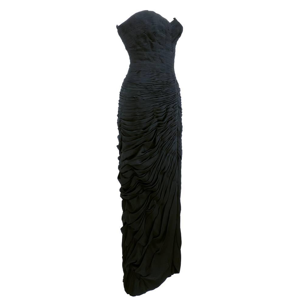 A work of art. 1950s Mingolini Guggenheim gown in black silk artistically pleated in an undulating manner.  Fully lined and has wonderful substntial weight. Fully boned bodice and figure hugging curves, Weighted hem for picture perfect  silhouette.