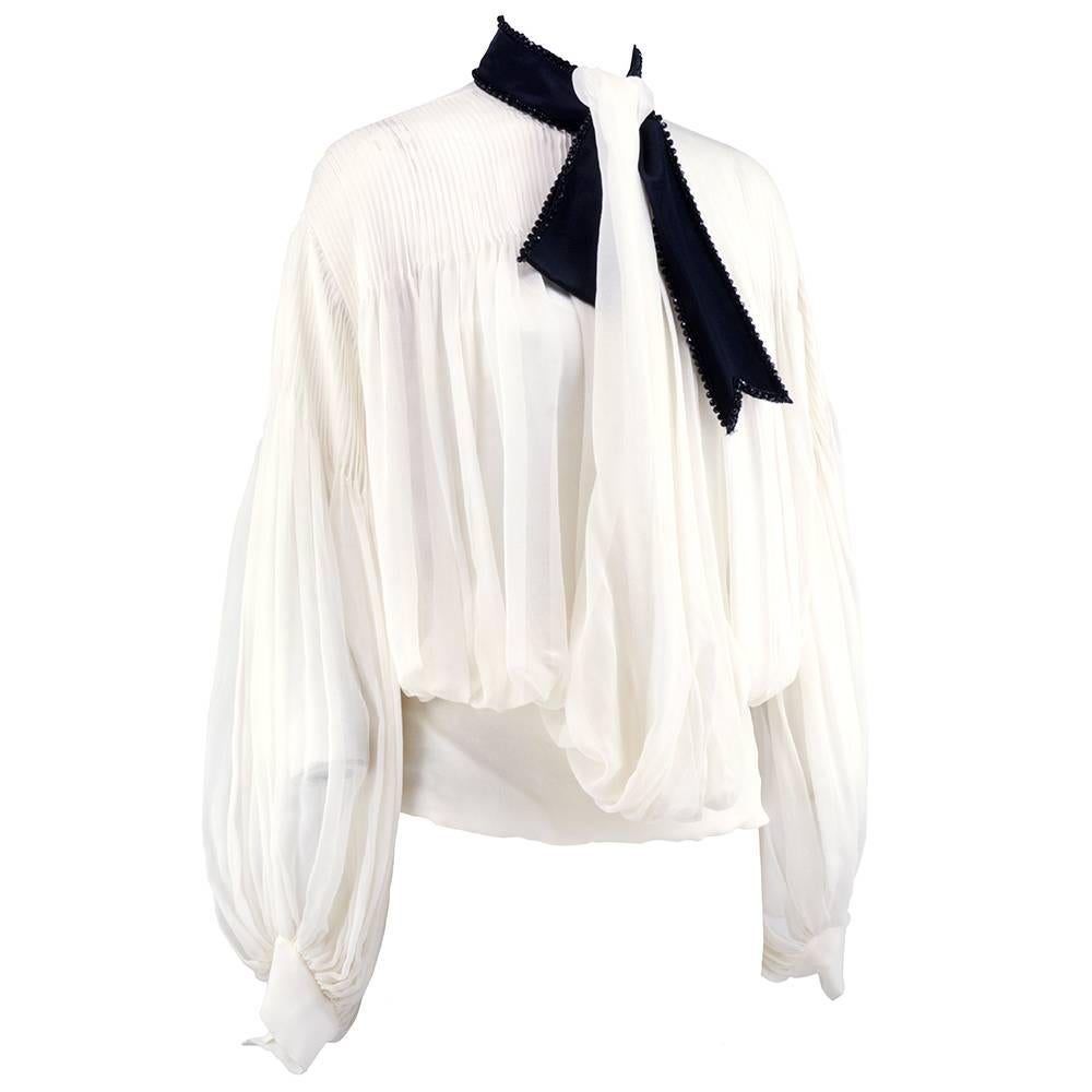 Beyond beautiful blouse by Christian Dior. Poet style with full, billowing sleeves, delicate pleats and wide banded waist. Contrasting black satin ribbon makes a standing collar with bow trimmed in jet black beads. Gracefully draped down front. Just