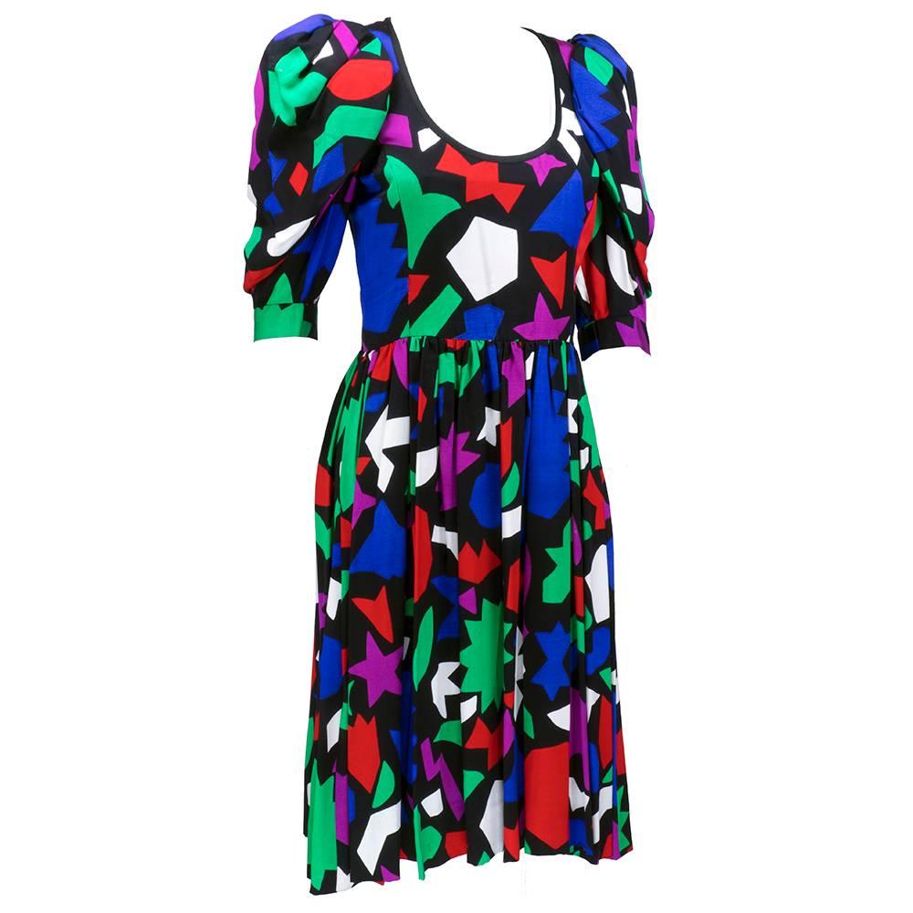 Circa 1980s dress by Saint Laurent's rive gauche label. Rainbow hued color block print on faille. Fabric drapes beautifully. Fit and flare style with gathered half sleeves. Half lined with a sexy neckline. 