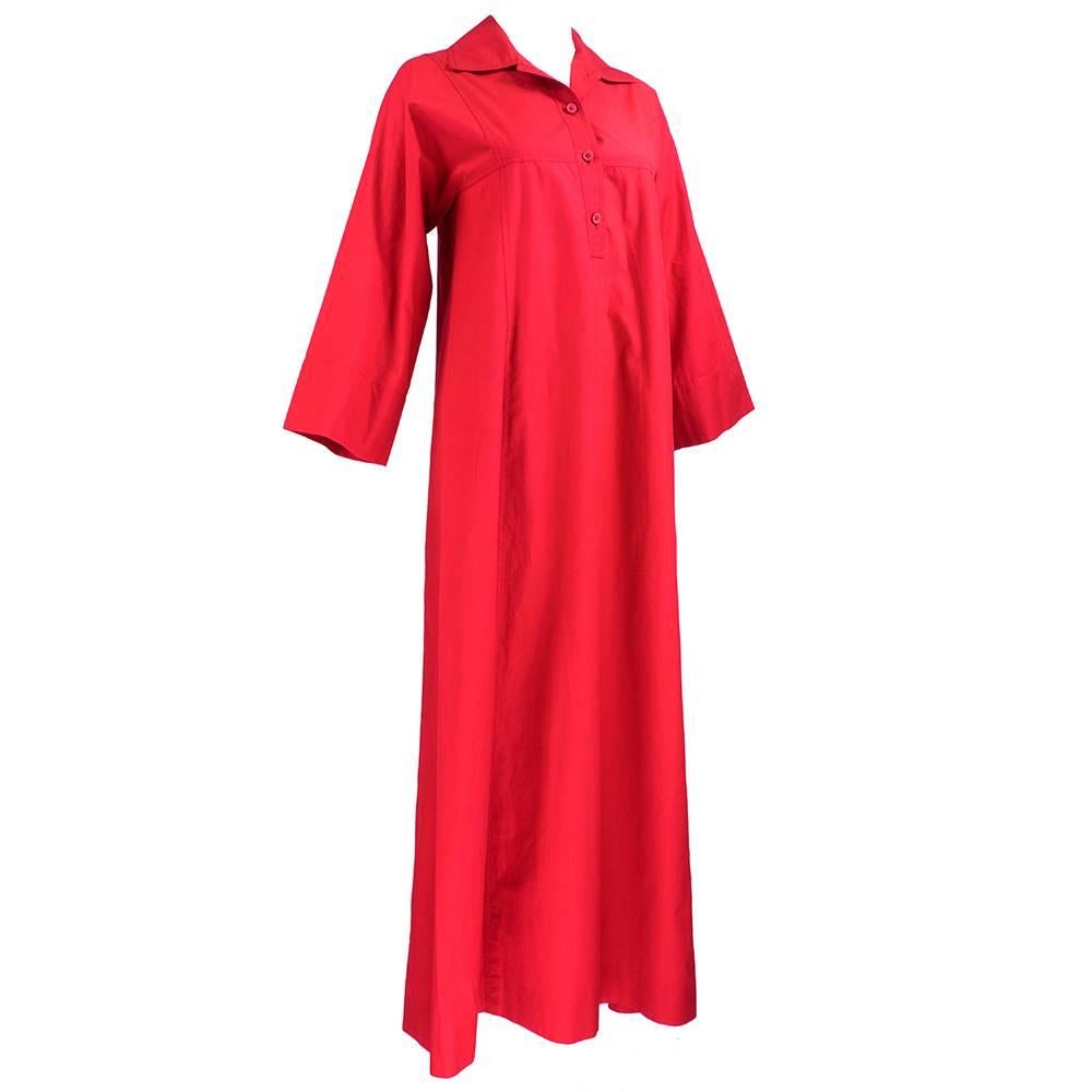 Super 70s casual look from Saint Laurent Rive Gauche circa 1970s. Red cotton tunic style caftan. slightly A-Line with hidden slash pockets and wide sleeves. Lightweight and perfect for summer. Slight overall, even fade give piece awarm, worn in