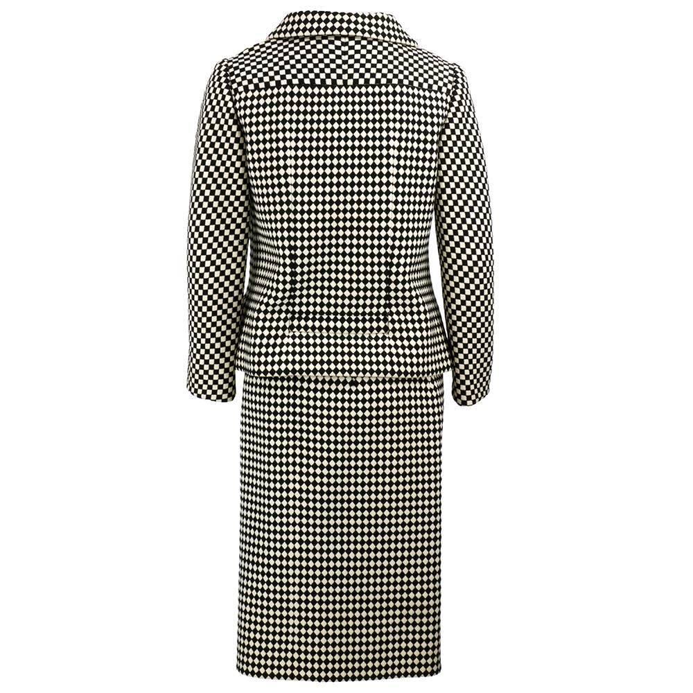 From the 60s that was more staid than swinging - A Valentino Couture two piece wool suit  in a very mod black and white. Classic boxy cut of the era with attached half belt that ties at waist.  Paired with a  simple pencil skirt. Fully lined. Top