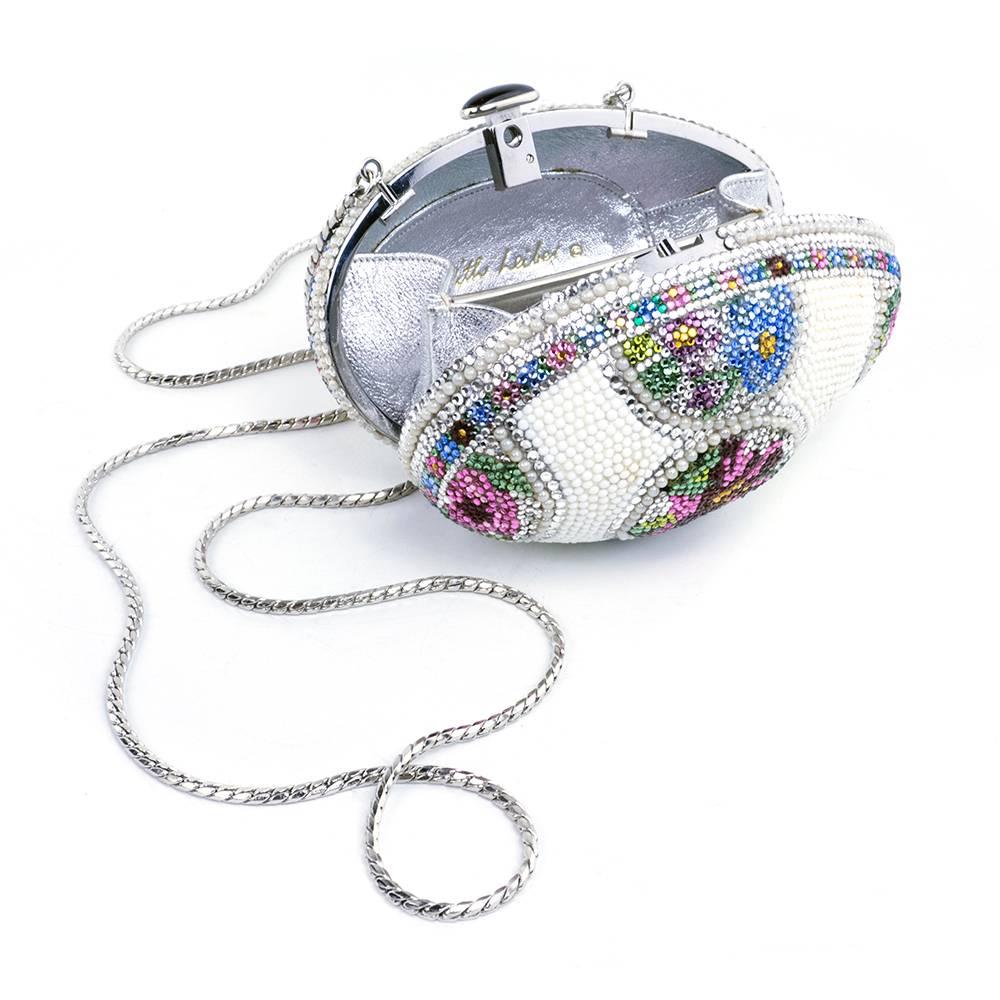 Stunning and highly collectable minaudiere by the queen of the evening bag - Judith Leiber. In the style of one of the famed Russian Faberge jeweled ornamental eggs. Lined in metallic silver with hidden shoulder strap. Very slight color loss on one