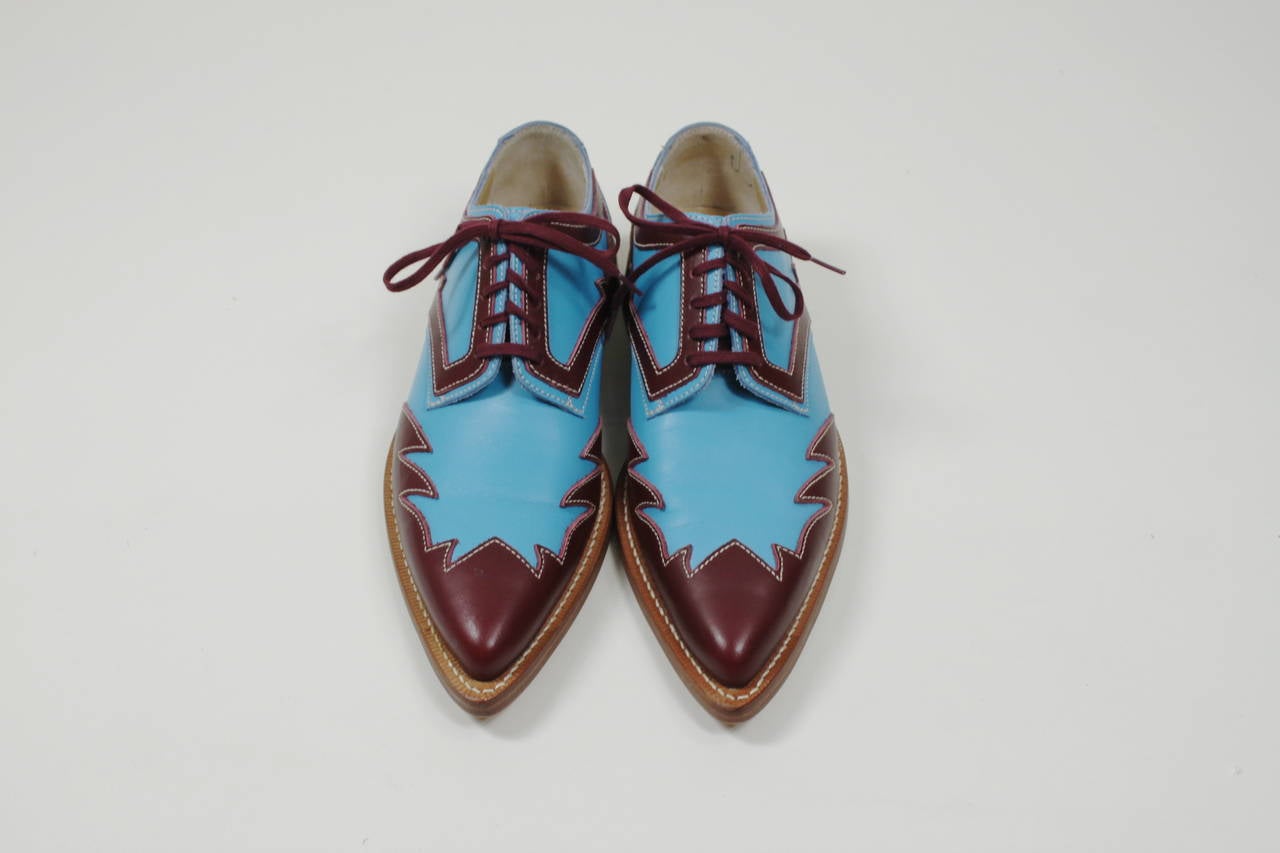 A wonderful pair of wingtip oxford shoes from Comme des Garçons. Done in contrasting burgundy against vibrant blue, the graphic wingtip motif is done throughout the shoe.

*Marked a Japanese size 23, which is technically a US 6.5