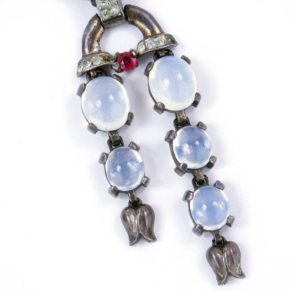 Iconic piece by legendary jewelry maker Trifari. Sterling silver brooch in peacock like fan with deco styling. with moonstones and faux rubies and rhinestones. With tiered dangles.  Lovely patina.  