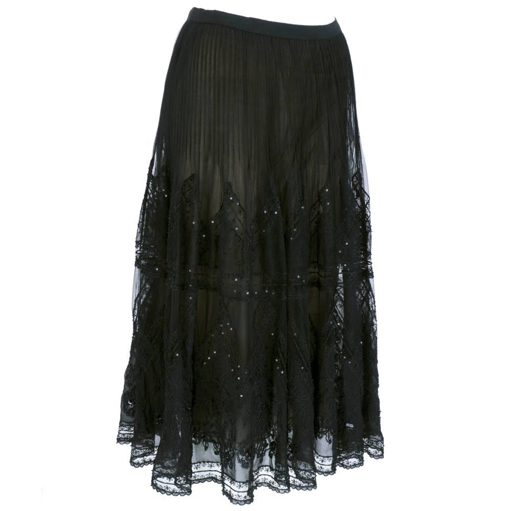 Heavily embellished evening skirt by Oscar de la Renta. Sheer black full skirt with lace and net inserts. Embroidery detail accented with beads and sequins. Pleated to hip and fully lined. Sheer and fully lined in nude silk.