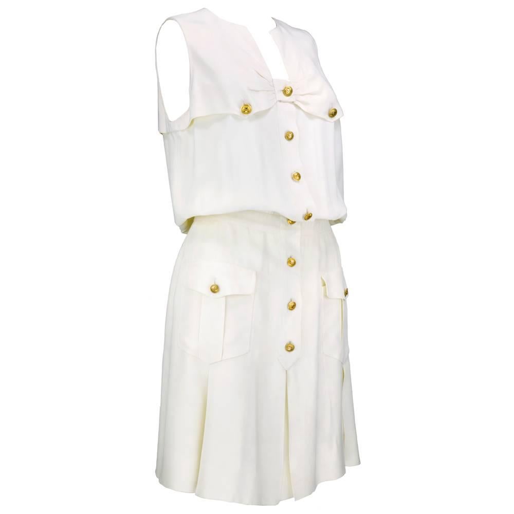 The polar opposite of the Chanel  little black dress - the Chanel little white dress.  Nautical look with button front closure, pleats at skirt and patch pockets and fitted waistband. Finished with 13 signature double C logo buttons. Half lined with