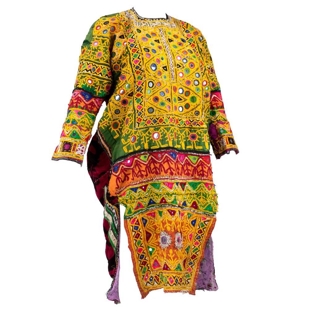 Incredible, beautifully worn tunic from the Banjara people. Typical festive colors, intense embroidery and inset mirrored discs. Multi-color patchwork of cooton and velvets.  Backed in luch velvety fabric in red and burgundy.  A gorgeous piece of