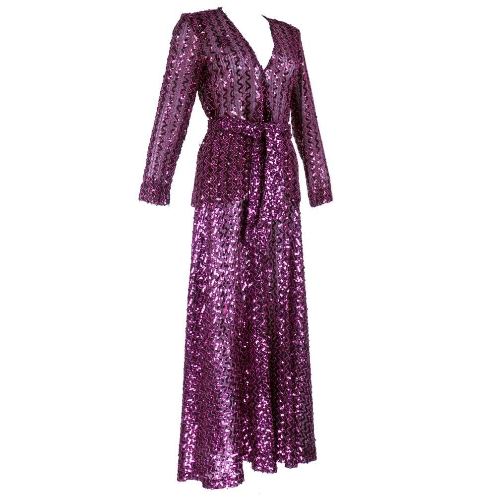 Glam rock madness! Semi-sheer, black lightweight fabric heavily embellished with magenta sequins and metallic trim. Wrap style jacket that rides lower in back with elephant bell pants.  Super sexy - super 70s. With matching sash belt. To live out