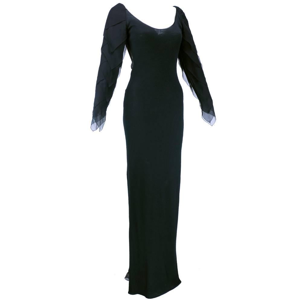 Slim silhouette gown by everyones favorite designer James Galanos. Fine wool body with sheer panel at back creating low back  effect. Petalled sleeves in chiffon and flounce at rear from derriere to ground. Lightweight, body hugging and made for