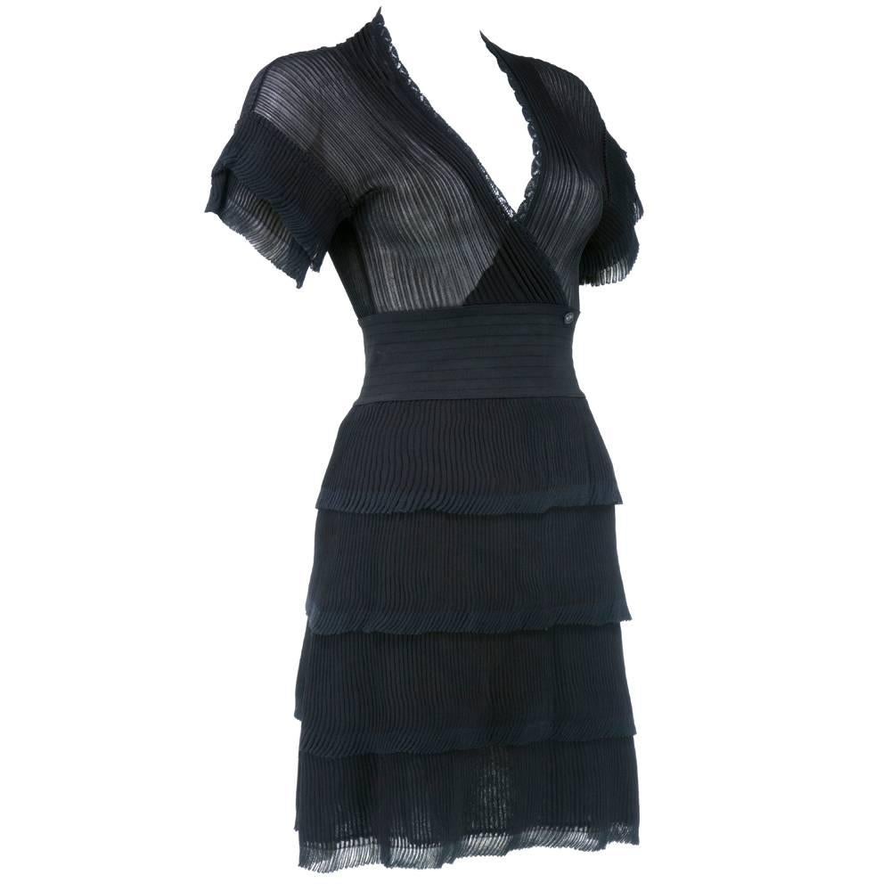 A modern twist on the little black dress, this Chanel black pleated number is done in ultra lightweight pleated fabric. The sweet silhouette is offset by 4 playful pleated flounces in the skirt and sleeves.  Because this is a knit dress, there is