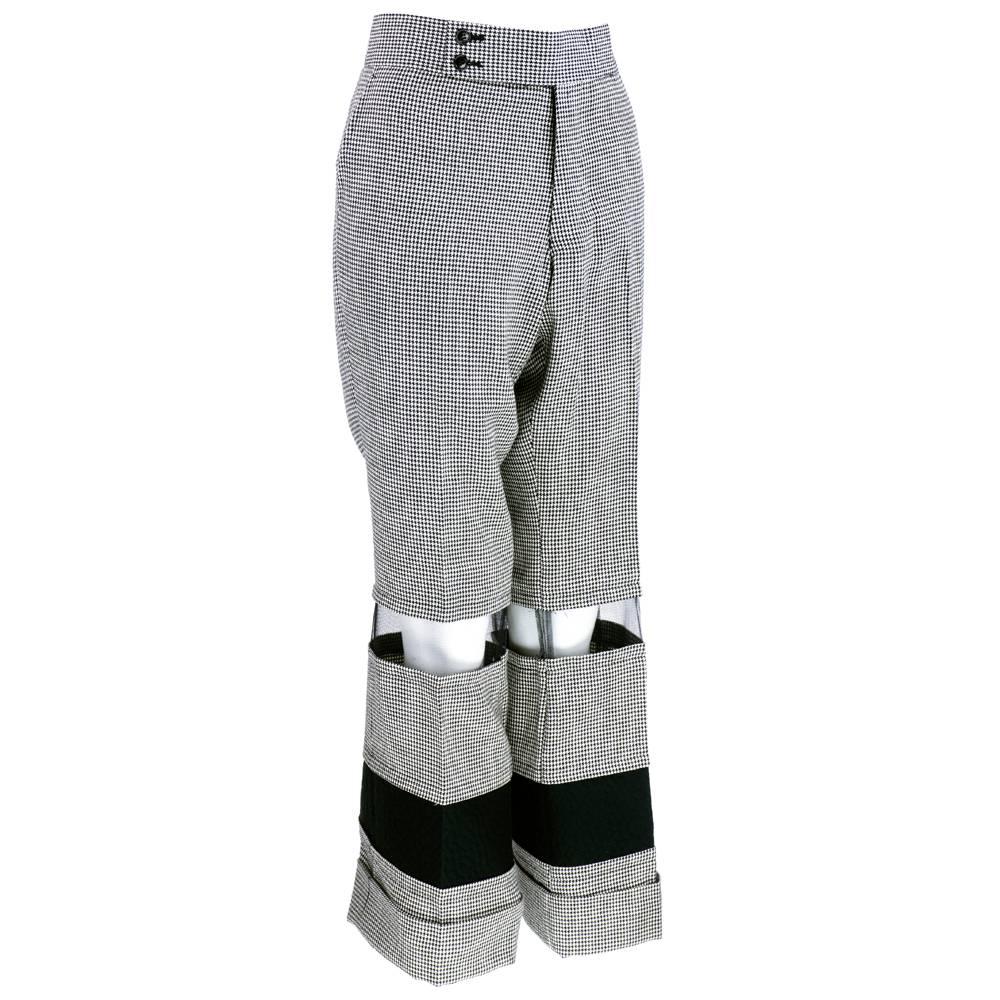 Whimsical and cleverly constructed pants in black and white houndstooth by Comme des Garcons from 2001. Flared leg with deep cuff with sheer mesh and quilted panels. 100% wool.