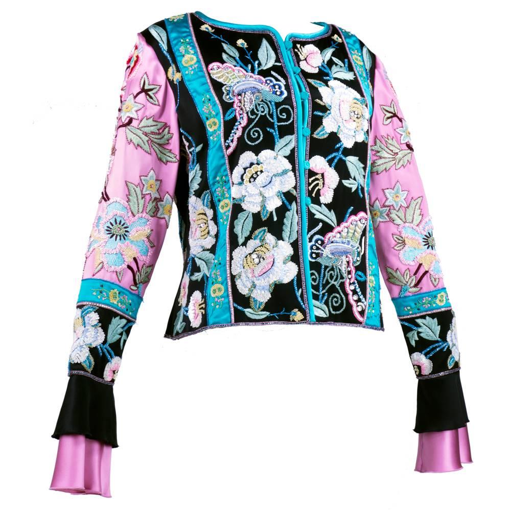 This ornately embellished silk evening jacket from Valentino is made from color-blocked satin in rose pink, black and turquoise. Gorgeous blossoms and butterflies are embroidered along the panels, accented by densely sewn micro sequins and glass