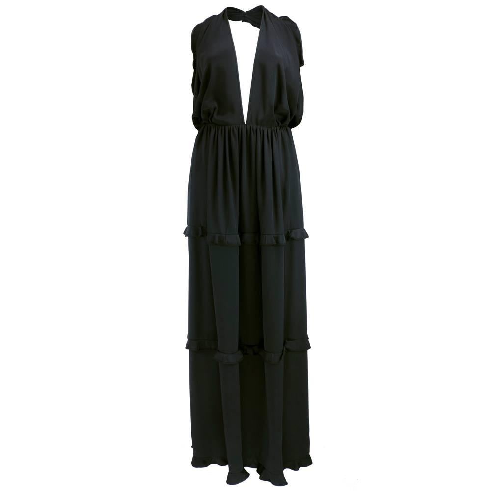
From James Galanos circa 1970s an impeccably constructed evening gown. Halter style with deep V neckline and tiered full skirt accented with ruffles. High slit to knee. Comes with matching stole. All in weighty silk and fully lined. Sexy and