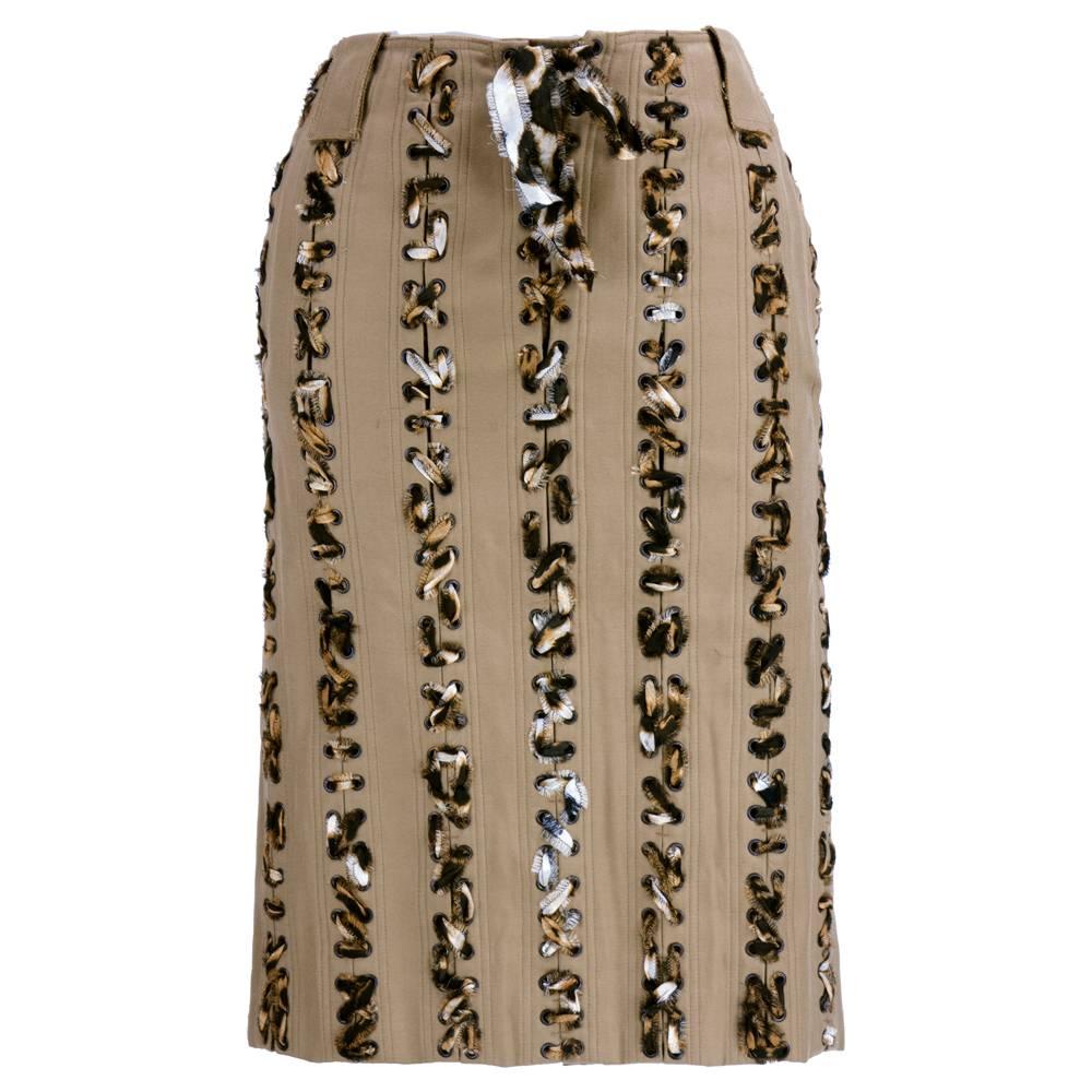 Two piece ensemble by YSL attributed to Tom Ford. Complementary tones of brown and tan with a ruched top and skirt with braided accents in frayed leopard fabric strips.

Skirt-
Waist: 30"
Length: 24"