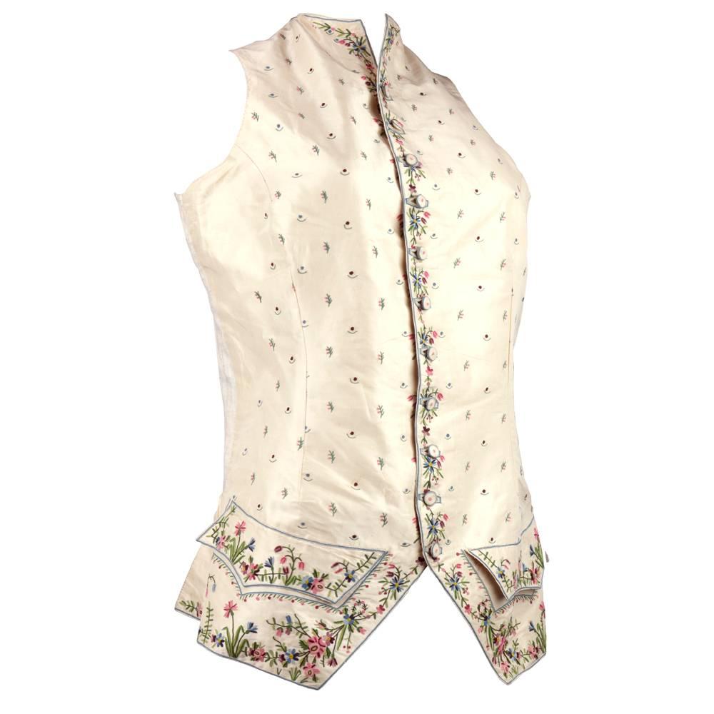 Mens 18th  century silk embroidered waistcoat.  Ivory silk front with delicate floral embroidery. One button missing, tear inside pocket, two tiny spots. Alteration under one arm otherwise very good condition for such an antique!