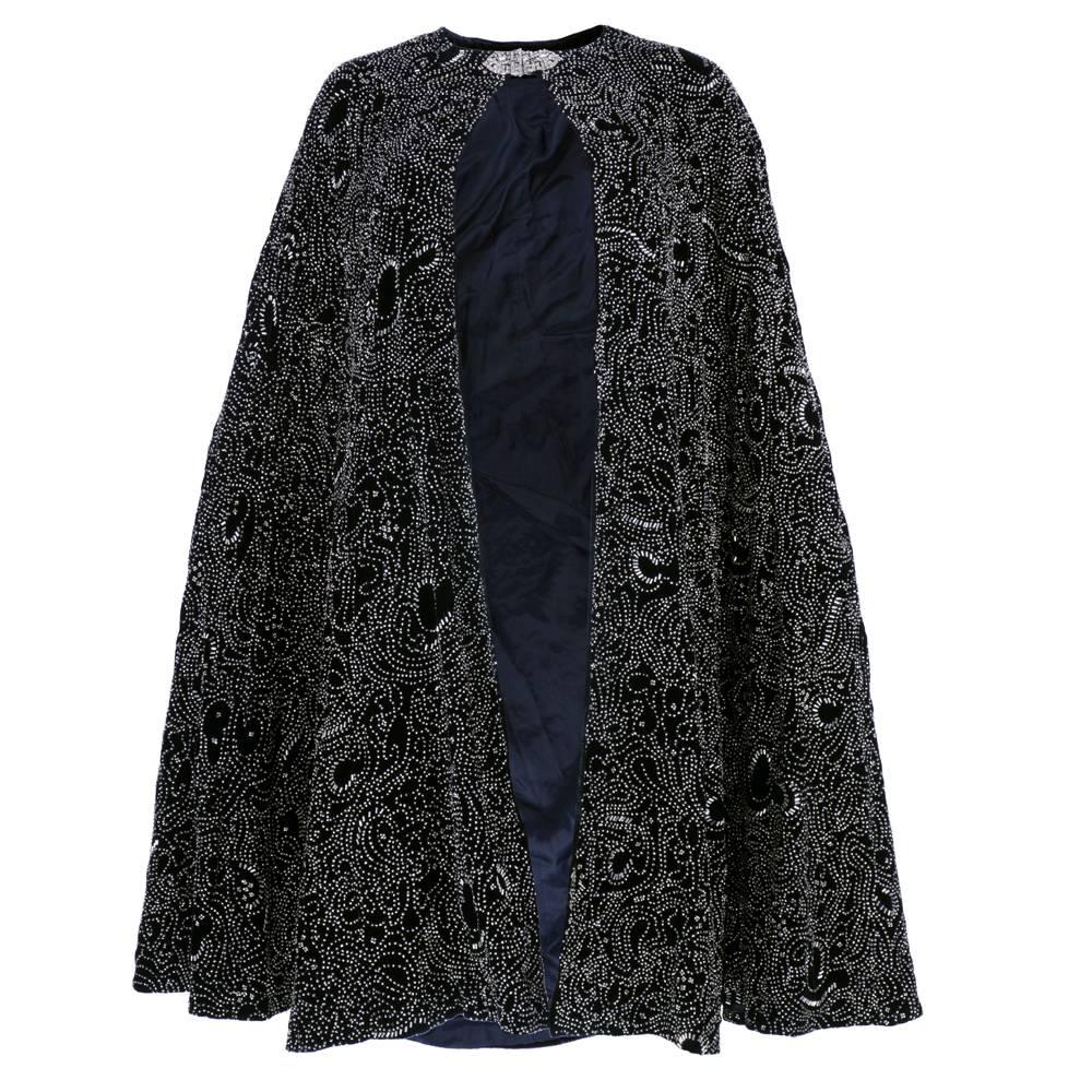 Absolutely stunning evening cape circa 1980s from Ralph Lauren's Purple Label. Heavy black rayon velvet heavily embellished with crystal clear beads. Fully lined with gorgeous deco style rhinestone clasp at neck. Drapes beautifully.  Vintage looks