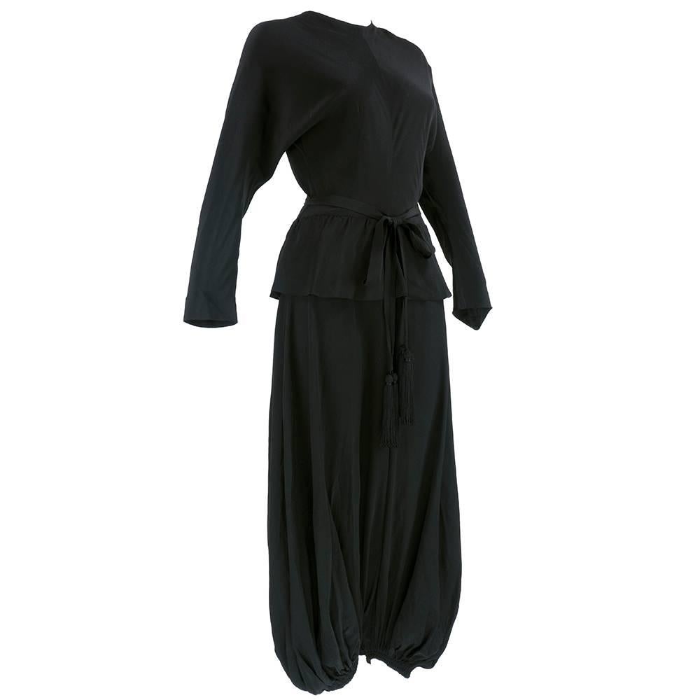 The best jumpsuit we have seen so far. Frm Lanvin circa 70s one piece black silk jumpsuit with cropped and gathered knee length legs. High neck, long sleeve top with full peplum. Comes with sash belt with tassel. Lightweight and easy to wear.
