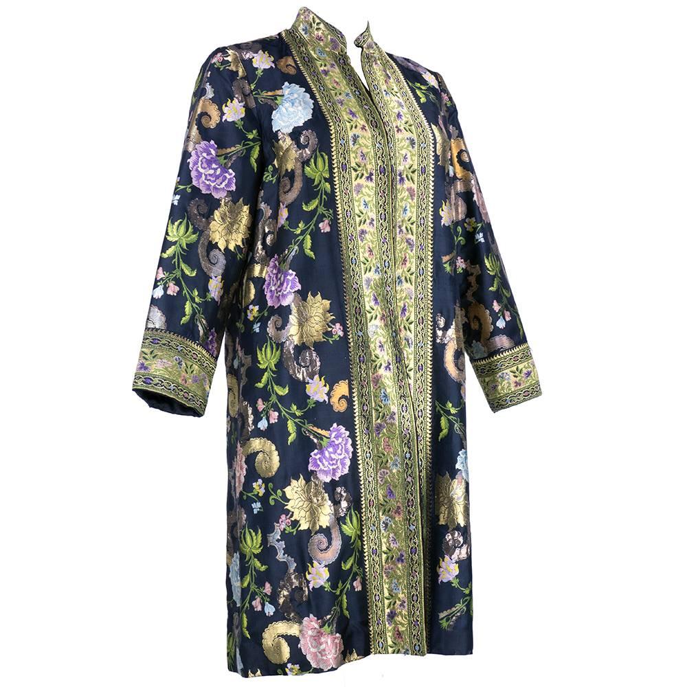 Incredibly regal and sumptuous. Vibrantly hued metallic brocade floral patterned evening coat by Profils Du Monde circa 1960s. Trimmed in coordinating gold trim. Fully lined and red carpet ready.