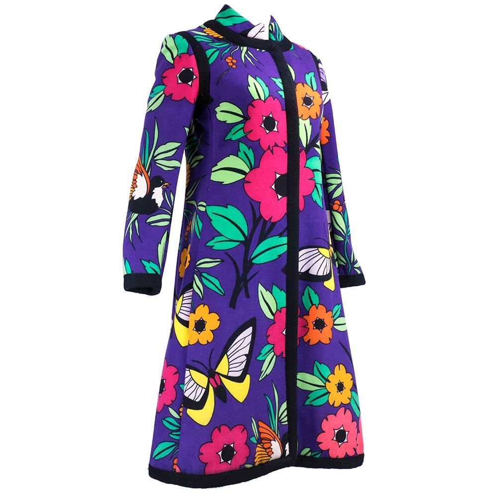 The most fun coat we have ever seen by great American designer Donald Brooks circa 1960s. Purple with cartoon floral and butterfly print. Edged in black trim. Snap closures. Heavyweight wool blend for a warm, cozy and colorful Winter. Fully lined