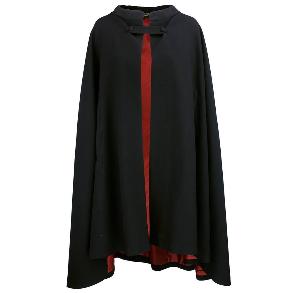 Exceptional Pierre Cardin cape circa 1960s .  Black wool twill with rust lining. Closes at neck with 2 button band with finished armholes.  From the height of the mod era.  Some wear at neckline but otherwise in excellent condition.