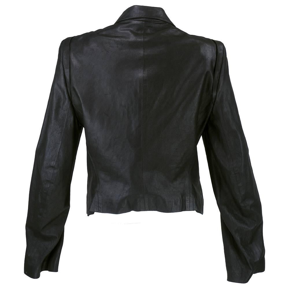 Trench style double breasted jacket in black leather by Ann Demeulemeester. Fully lined with slash pockets and distressed look texture. Foldover collar detail.