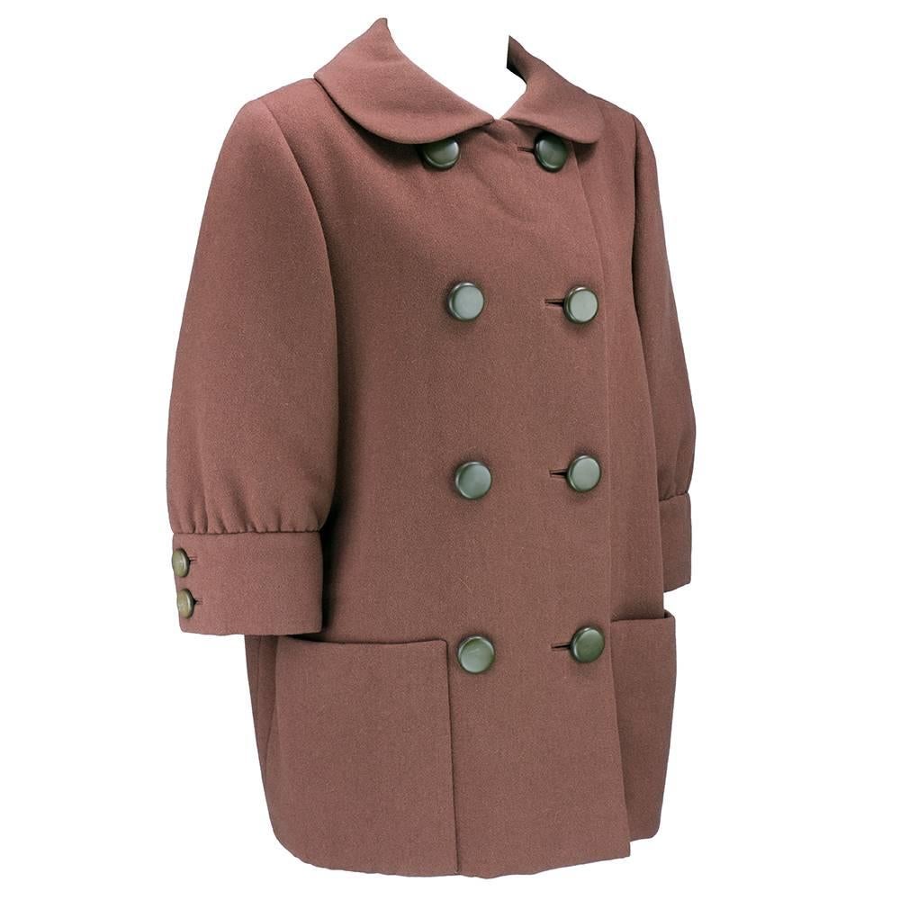 Super chic little overcoat by American designer Norman Norell circa late 1950s early 1960s. Heavyweight wool double breasted with oversize buttons and exaggerated features - oversized collar, patch pockets and gathered quarter sleeves. Fully lined. 