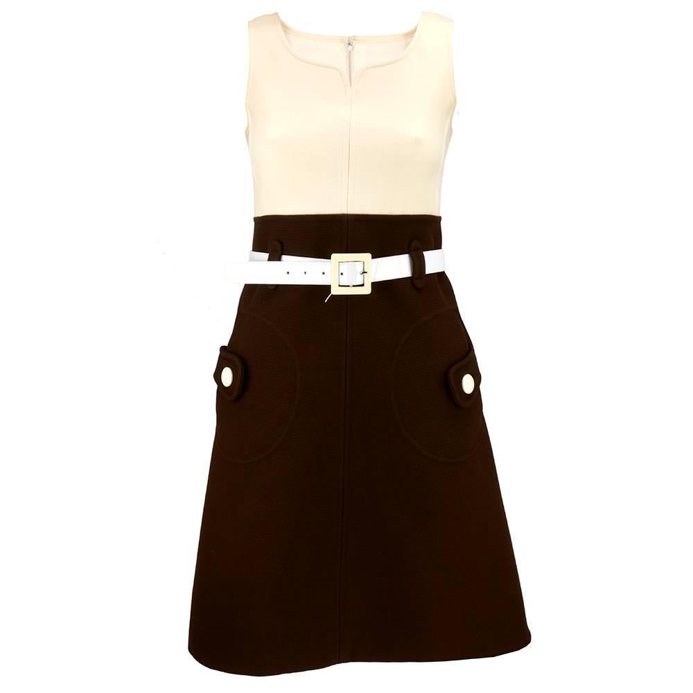 Classic piece from iconic designer Andre Courreges circa 1960s.   Ivory and chocolate brown dress with matching cropped box cut jacket with peter pan collar. Empire waist with flared skirt. Oversized patch pockets with button accents. Belt has been