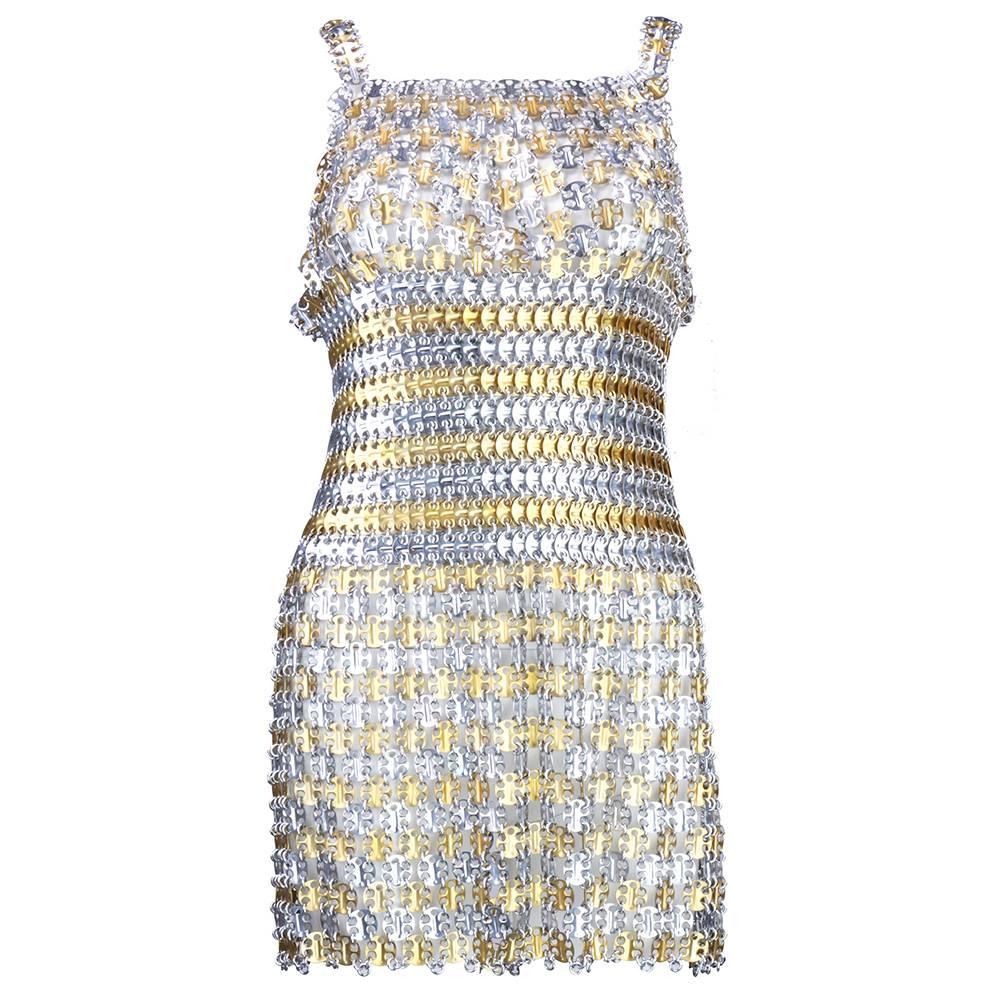 Metal gladiator style mini dress. Tank shaped bodice constructed of small molded metal disks and has contoured bra top.  Skirt is made of same metal disks with sections of square metal plates forming striped pattern.